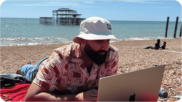 Sahil Gandhi working on a laptop on a beach